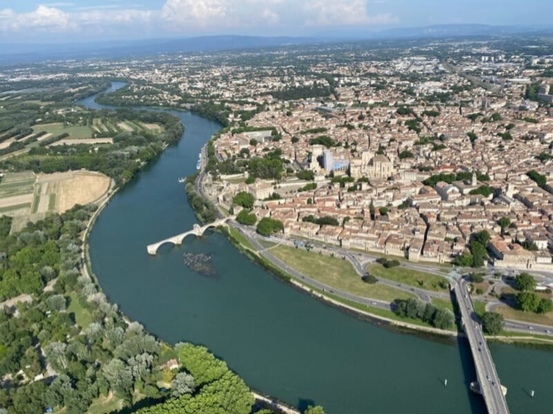Vue aérienne d'une ville traversée par une rivière lors d'un vol en ULM autogire près d'Avignon. 