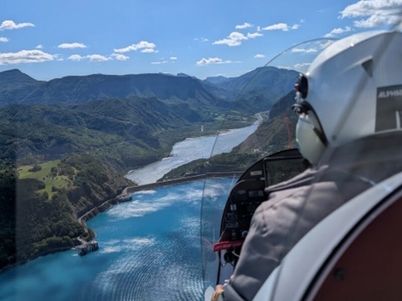 Pilote dans un ULM survolant une rivière sinueuse lors d'un vol en ULM autogire près d'Avignon. 