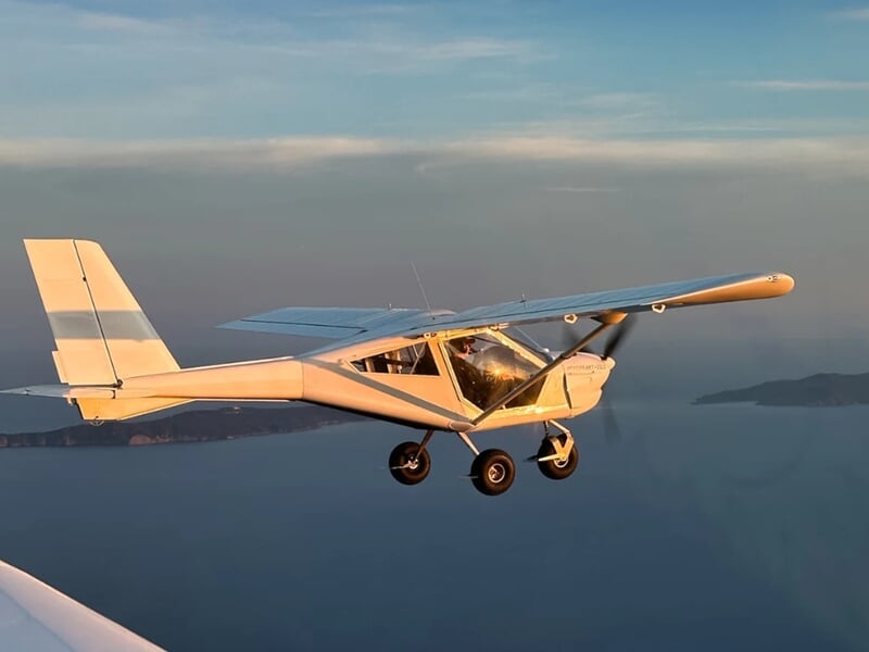 Petit avion ultraléger en vol au-dessus de la mer lors d'une initiation au pilotage d'un avion ULM près de Toulon.