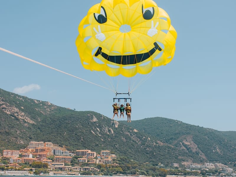 Trois personnes en parachute ascensionnel sur la plage du Neptune à Ajaccio.