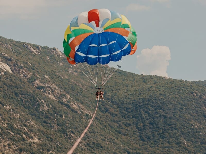 Deux personnes en parachute ascensionnel sur la plage du Neptune à Ajaccio.
