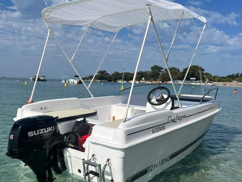 Bateau blanc avec moteur Suzuki, auvent et volant, sur une mer calme lors d'une location de bateau à Ajaccio. 
