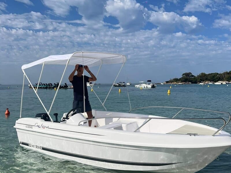 Homme debout sur un bateau blanc avec auvent lors d'une location de bateau à Ajaccio. 