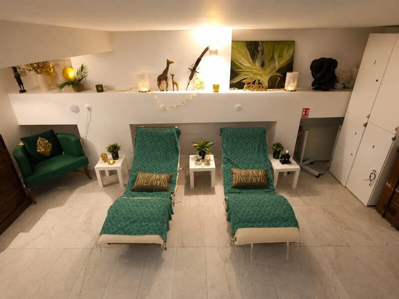 Deux fauteuils verts avec coussins décoratifs dans une pièce lumineuse et accueillante pour la détente.