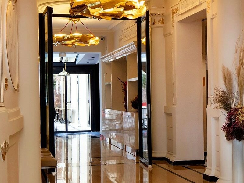 Entrée élégante d'un spa avec sol brillant, murs clairs et décoration florale raffinée.
