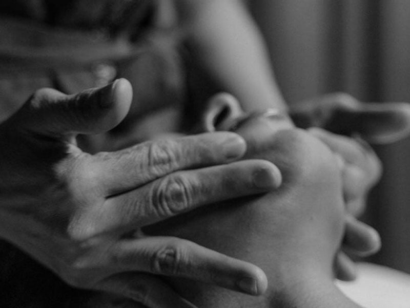Gros plan en noir et blanc sur des mains massant doucement un pied pour un soin relaxant