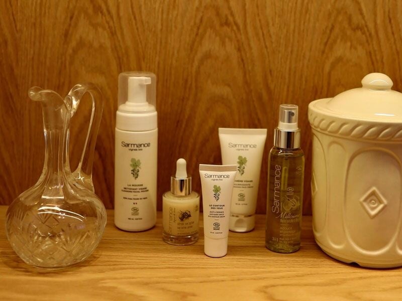 Produits de soin et beauté disposés sur une étagère en bois dans un spa