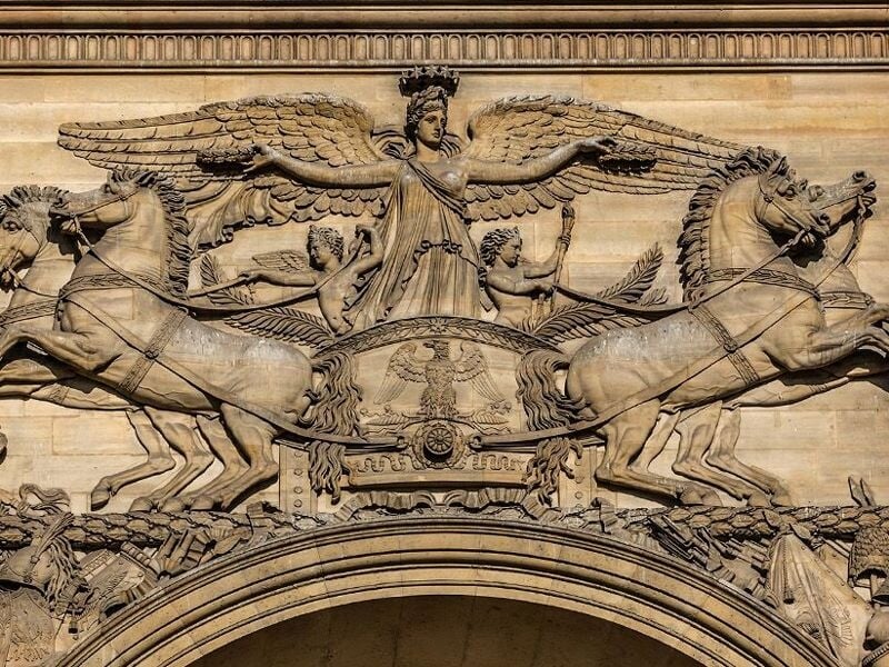Sculpture en bas-relief représentant un char antique tiré par quatre chevaux sur le Palais du Louvre à Paris.