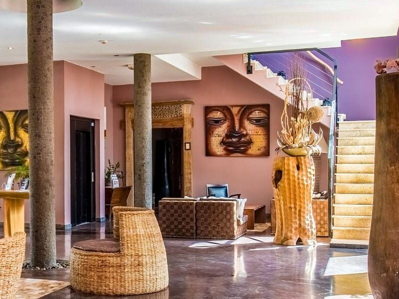 Un salon d'accueil de spa décoré avec des œuvres d'art asiatiques, des meubles en osier et une ambiance zen.