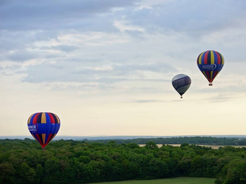 Groupe de montgolfières en plein vol au-dessus du Morvan près de Vézelay