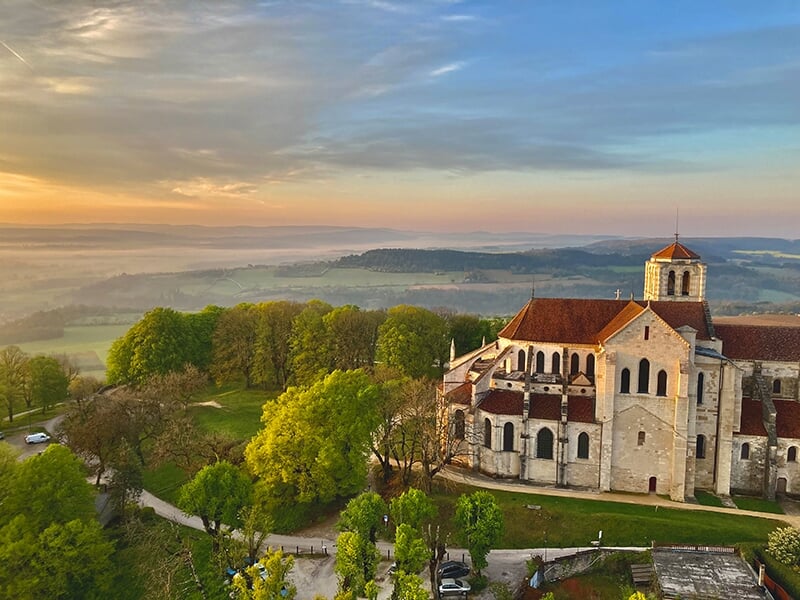 Paysage pittoresque d'une basilique sur une colline avec une vue dégagée sur la campagne environnante au crépuscule.