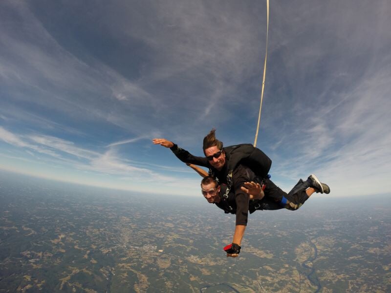 Deux personnes en chute libre lors d'un saut en parachute au-dessus de la campagne depuis l'aérodrome de Sarlat Domme.