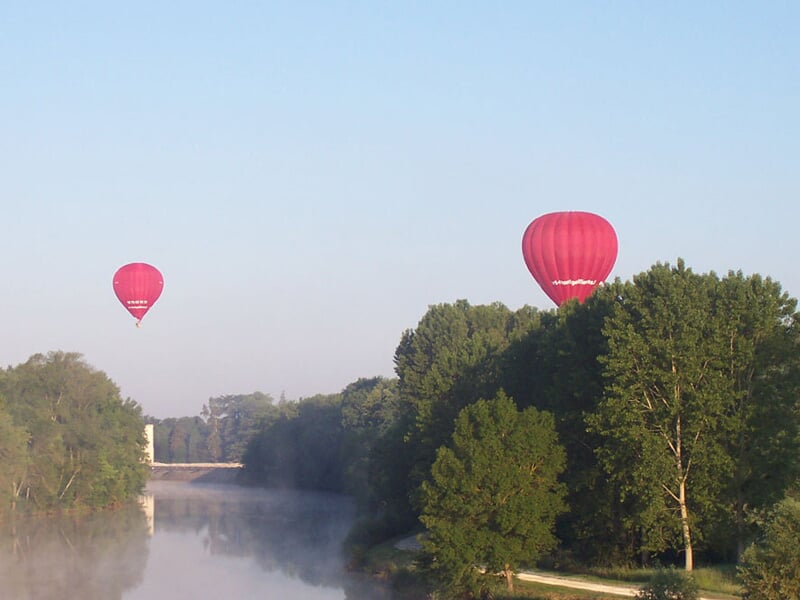Montgolfière colorée flottant dans un ciel clair avec des passagers dans la nacelle