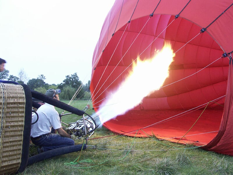 Montgolfière colorée flottant dans un ciel clair avec des passagers dans la nacelle