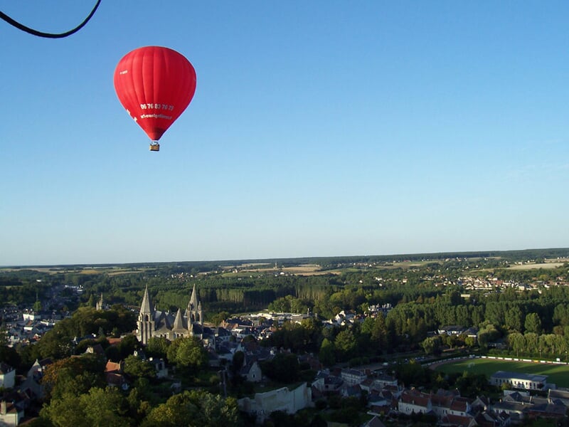 Montgolfière colorée flottant dans un ciel clair avec des passagers dans la nacelle