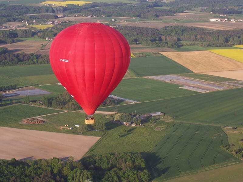 Montgolfière colorée flottant dans un ciel clair avec des passagers dans la nacelle