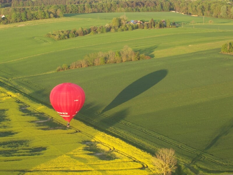 Montgolfière colorée flottant dans un ciel clair avec des passagers dans la nacelle