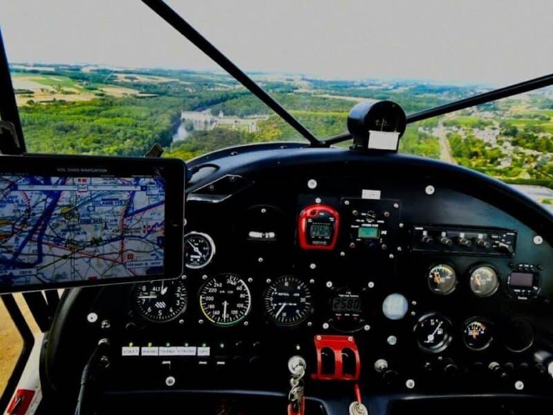 Vue depuis le cockpit d'un ULM en vol, avec instruments de bord et paysage verdoyant en arrière-plan, lors d'une initiation près de Blois.