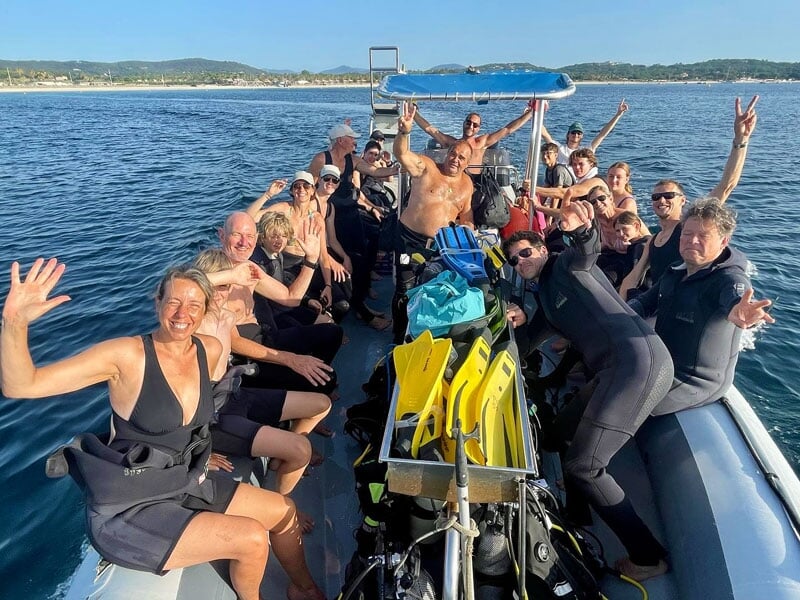 Un groupe de plongeurs posent sur le bateau de l'école de plongée