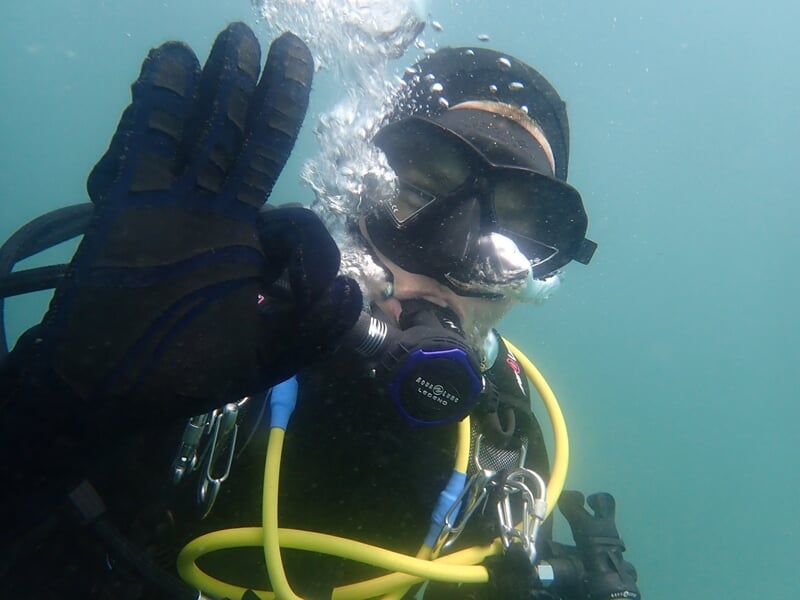 Un plongeur communique sous l'eau pour indiquer que tout va bien
