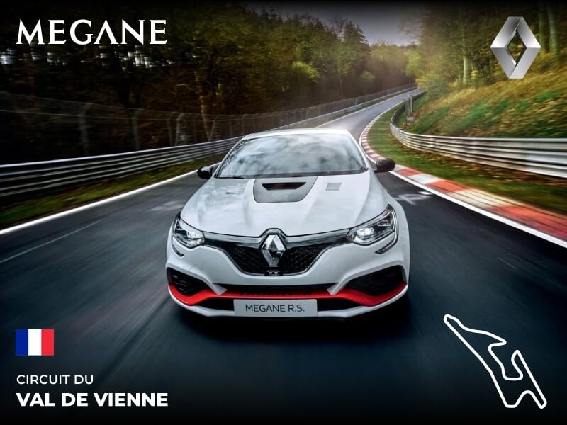 Voiture Renault Megane R.S. blanche sur circuit Val de Vienne, entourée d'arbres, vue avant dynamique en mouvement.