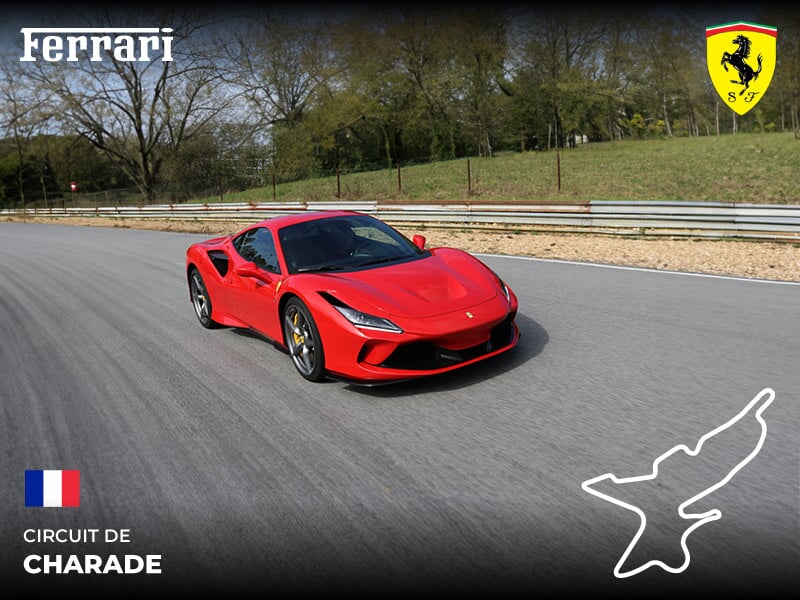 Voiture de sport Ferrari rouge sur circuit de Charade en France, entourée d'arbres et barrières de sécurité métalliques.